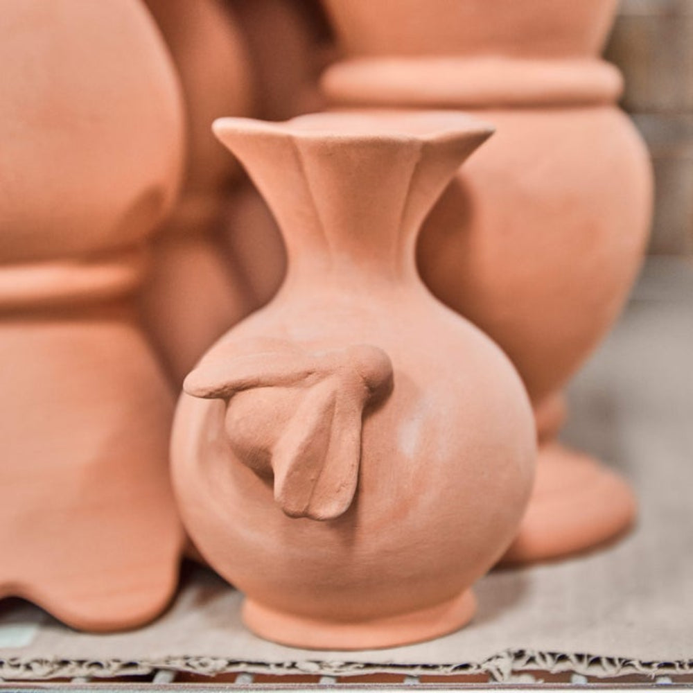 A red clay pre painted bee vase with others. 