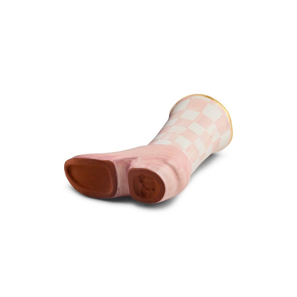 A ceramic cowboy boot planter from the MacKenzie Childs Lainey Wilson Collection, pictured from the bottom on a white background