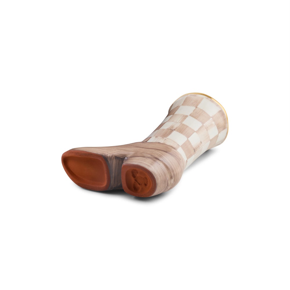 A ceramic boot-shaped object with a checkered beige and white upper and a reddish-brown foot sole, shown on a plain white background.