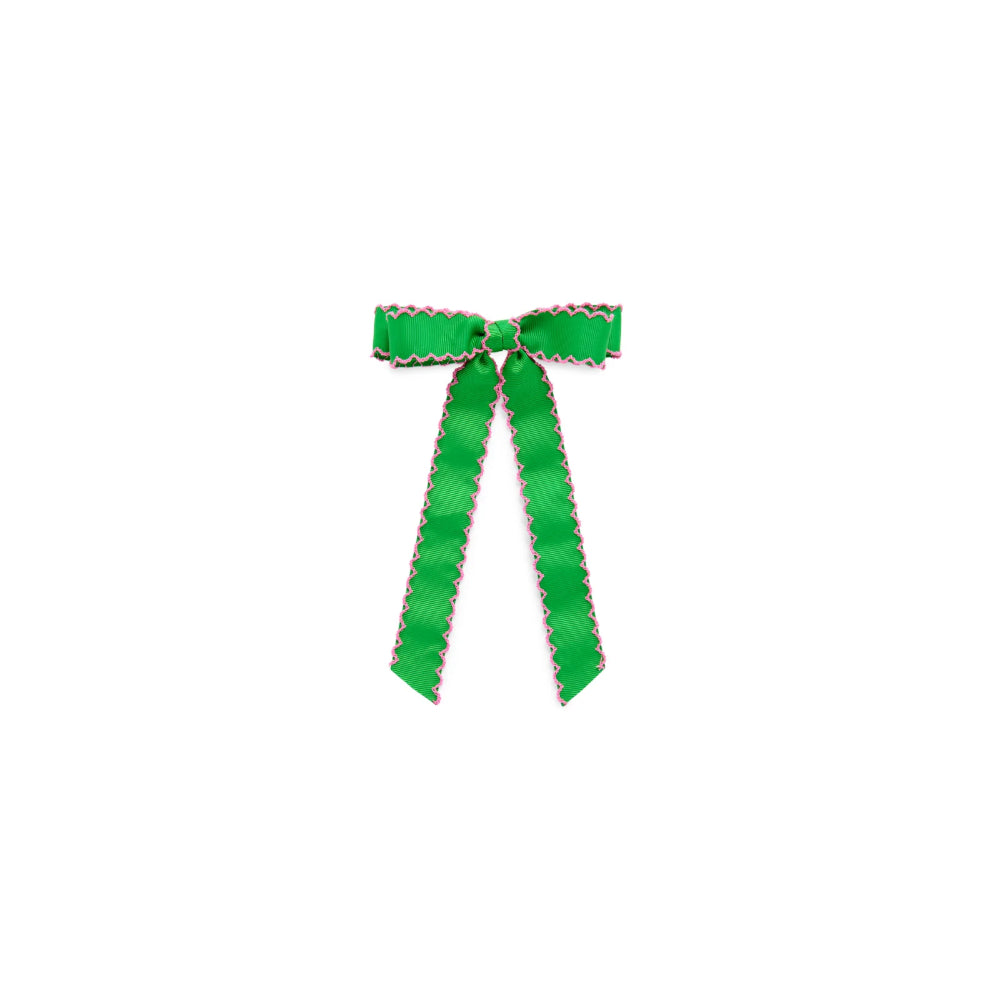 A bright green satin ribbon tied into a bow with matching long tails, featuring a scalloped edge with small white and red details, centered on a plain white background.