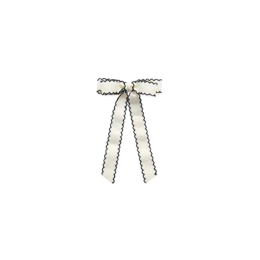 A white ribbon tied into a bow with a black scalloped edge, centered on a plain white background.