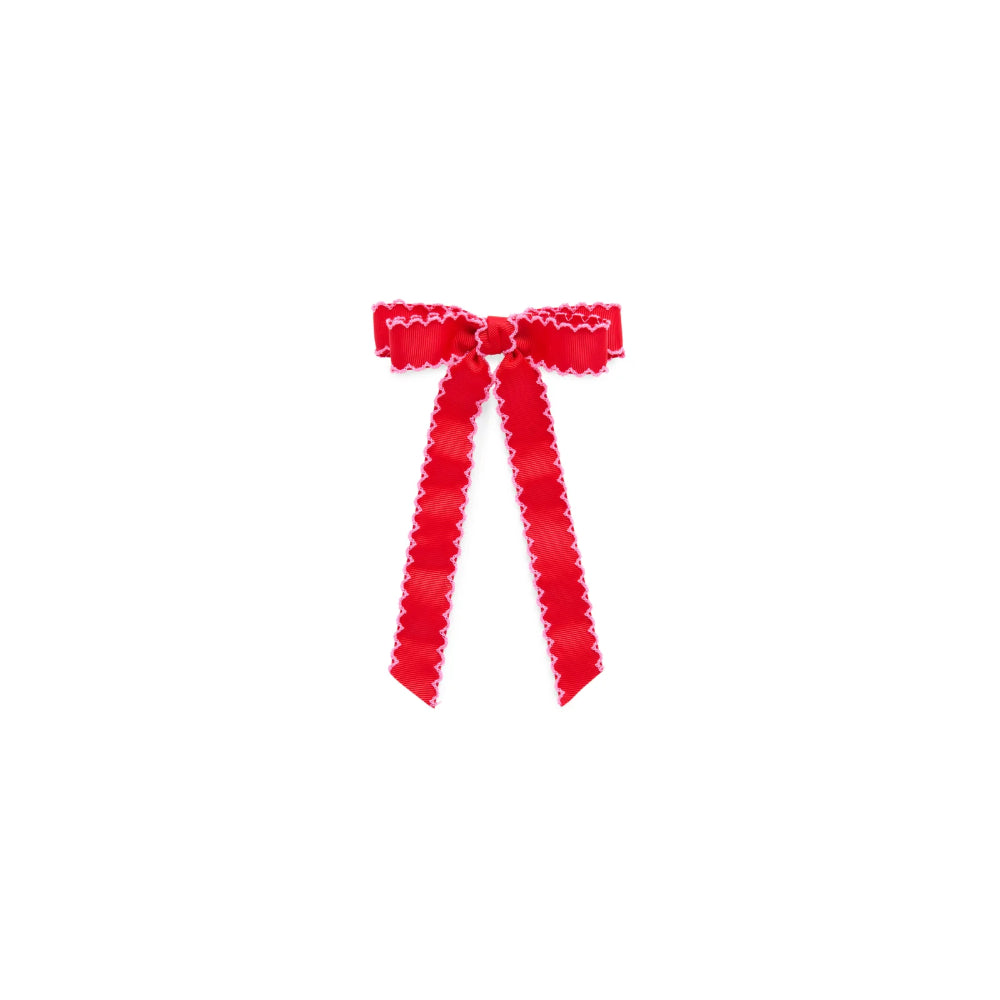 A small red ribbon bow with scalloped edges, centered on a plain white background.