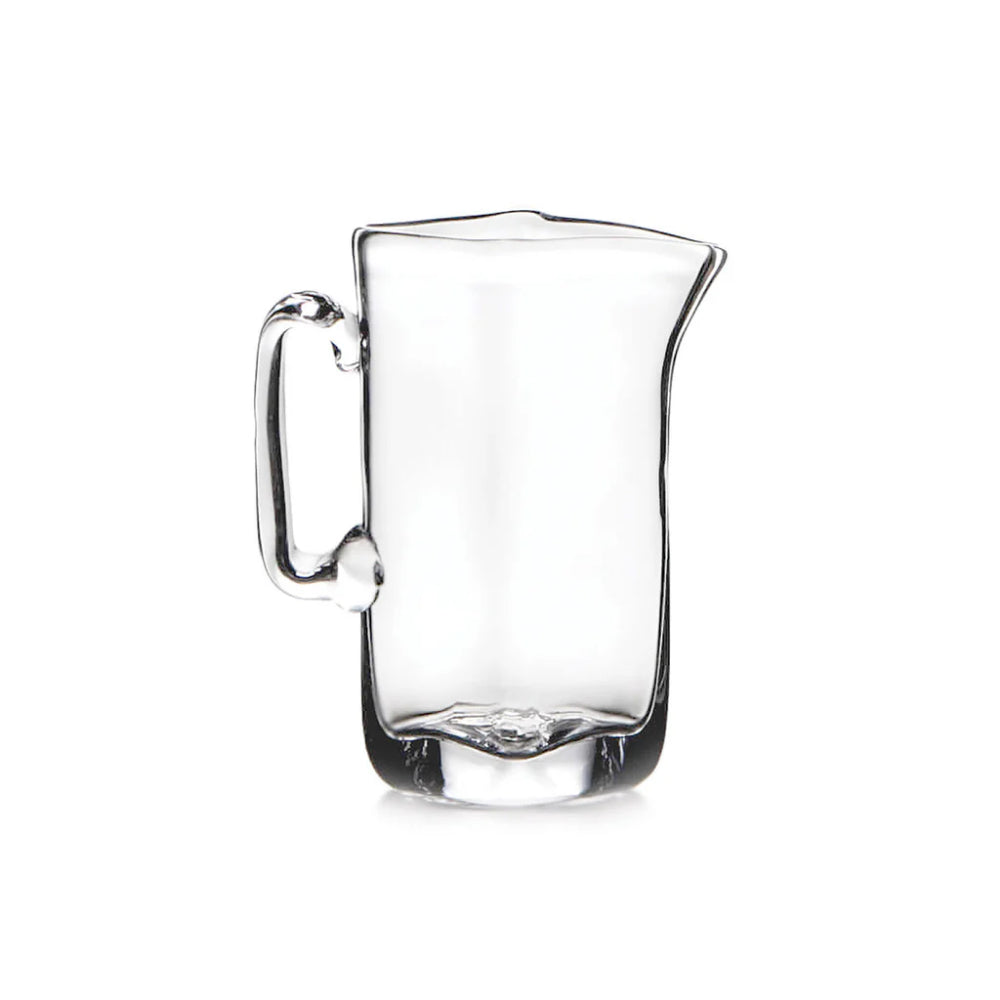 Small glass pitcher on white background