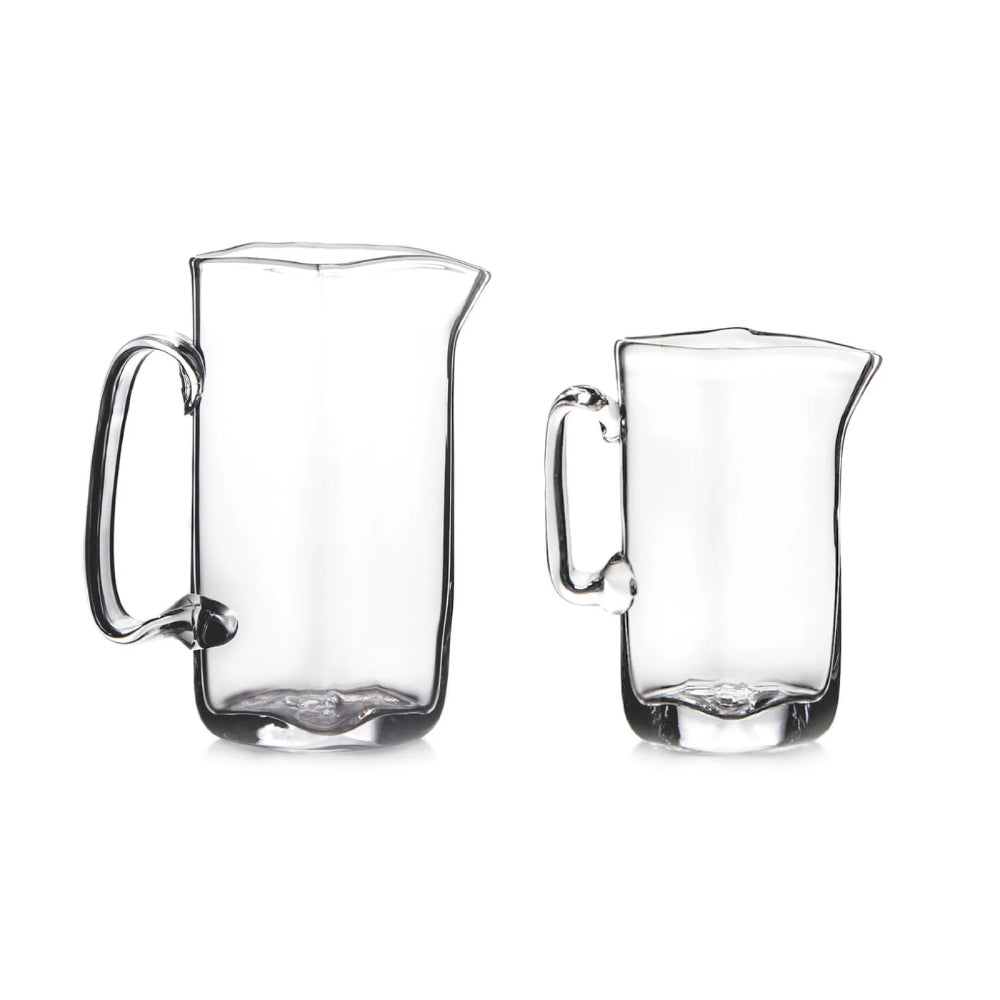 Two clear glass pitchers on a white background