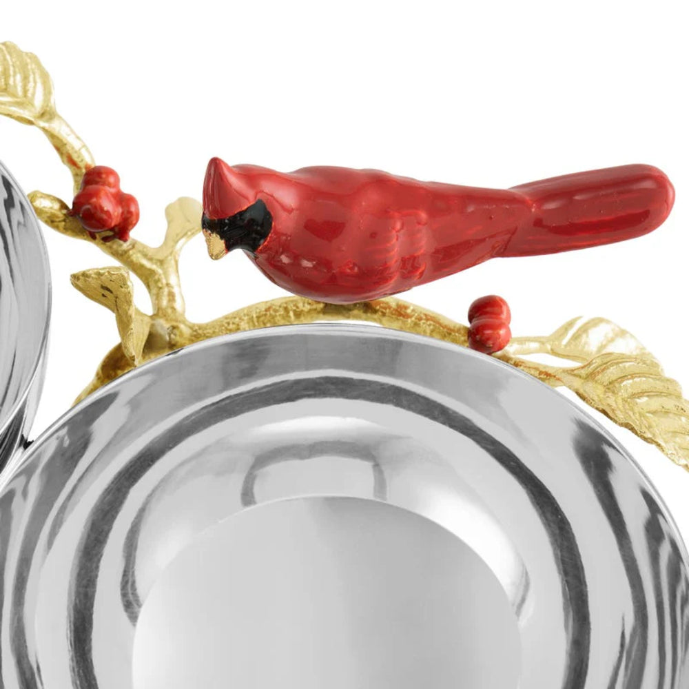 Decorative silver bowl with a red cardinal bird and gold branches on a white background