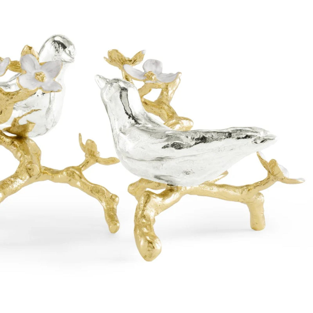 Decorative bird figurine with gold branch on a white background