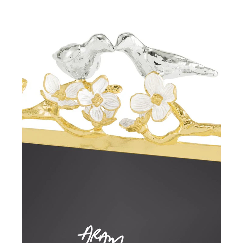 Decorative photo frame with gold accents, white flowers, and silver birds on a white background.