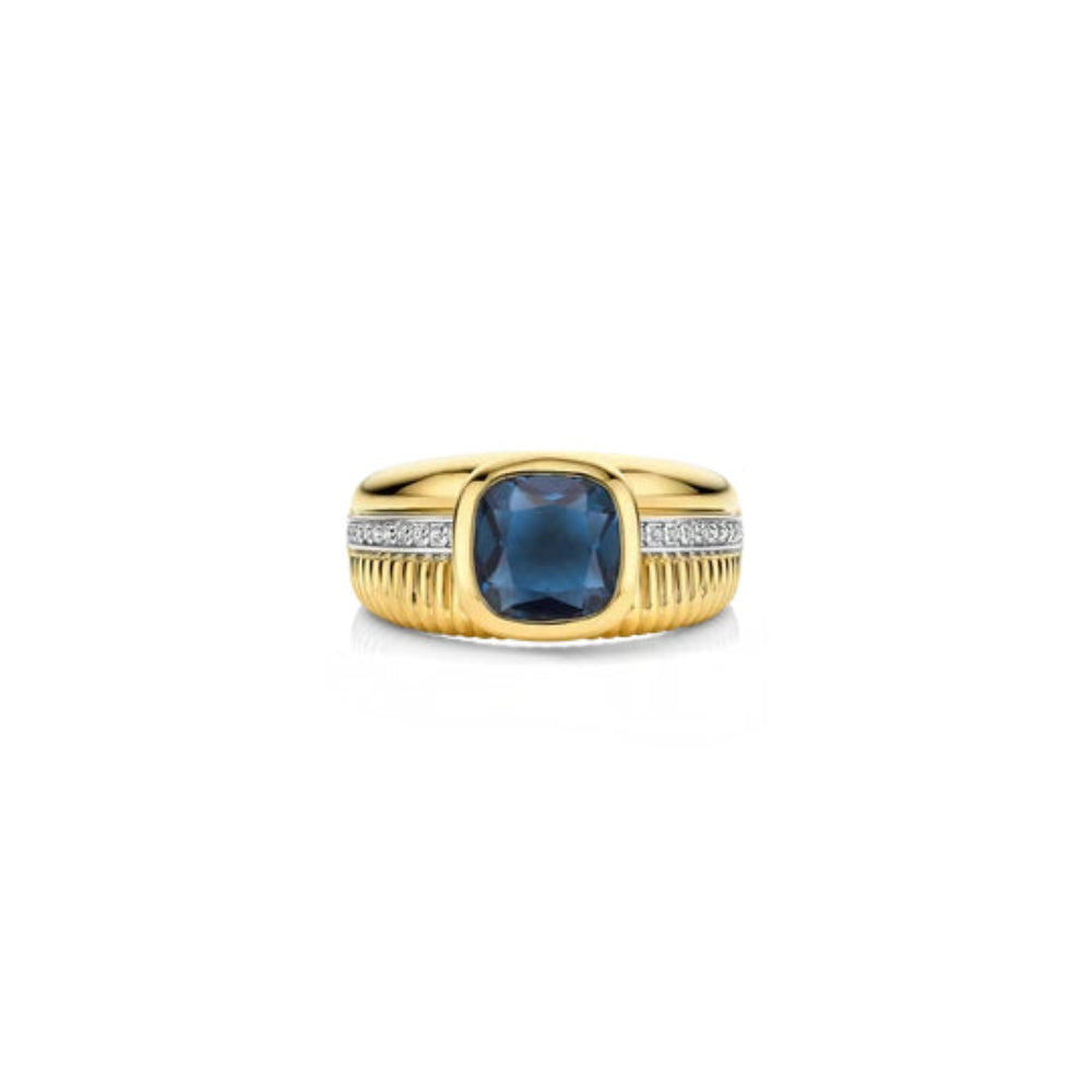 A yellow gold ring featuring a cushion-cut dark blue gemstone in the center, flanked by pavé-set clear stones and a ribbed textured band