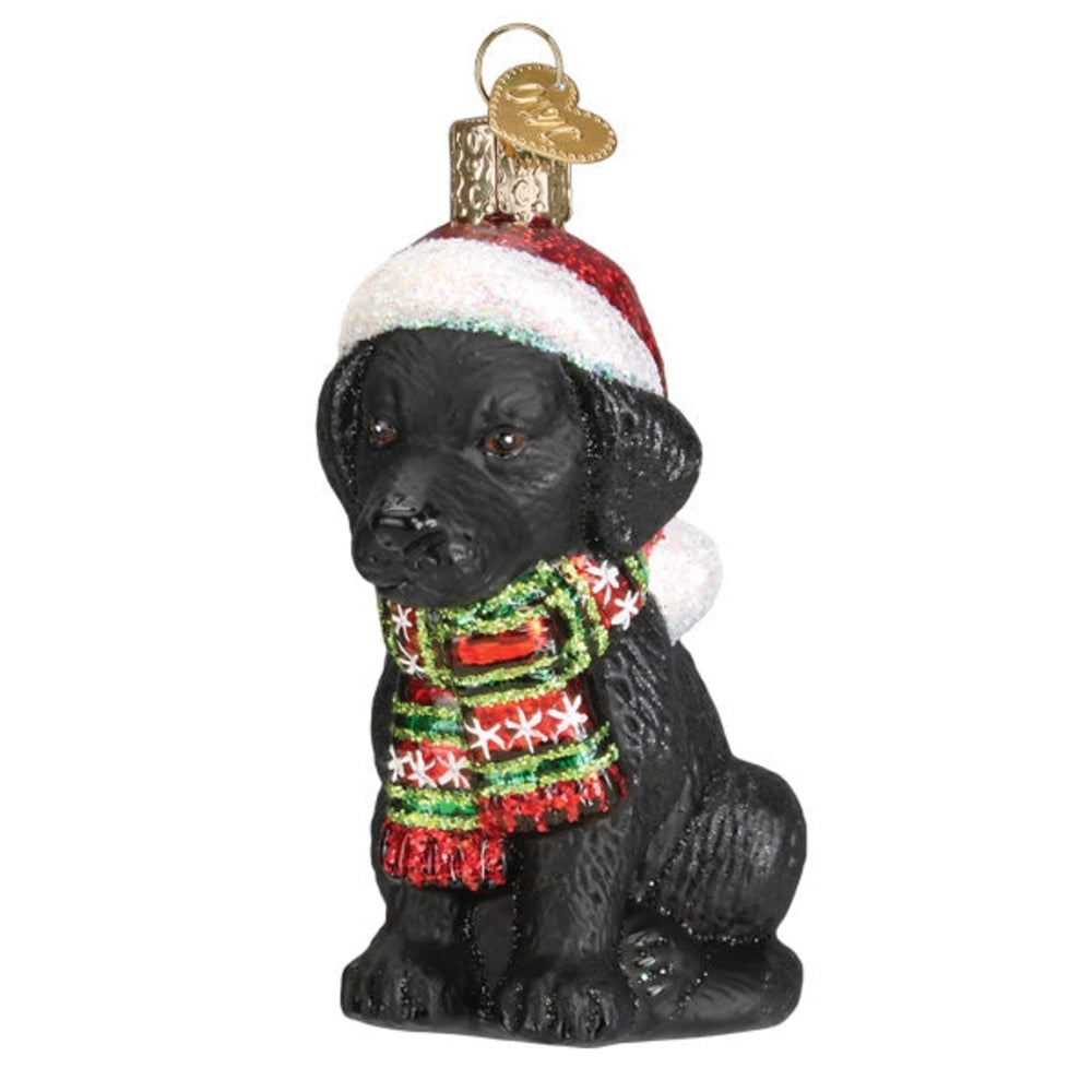 Black dog ornament wearing a Santa hat and scarf on a white background.