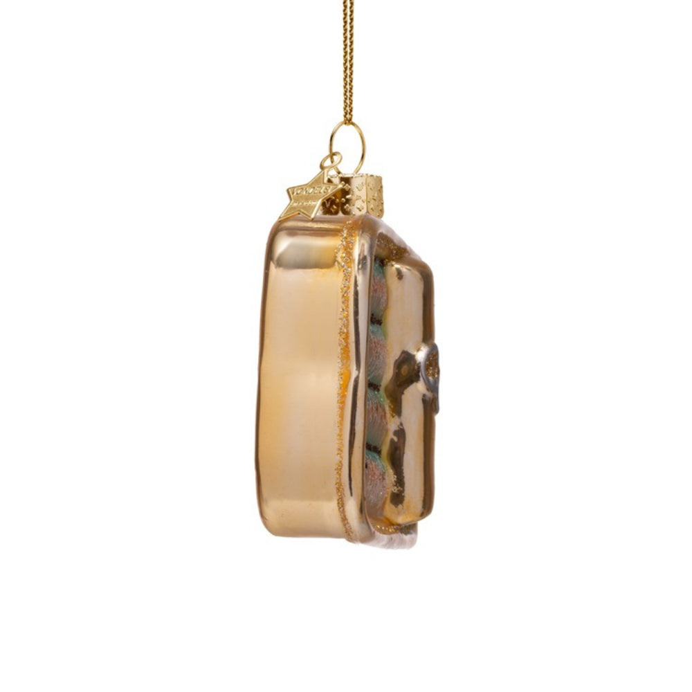 Gold glass ornament with intricate design on a white background