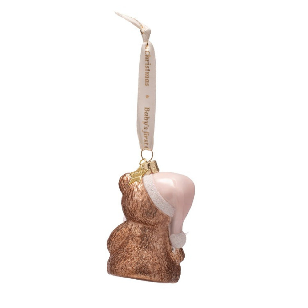 Christmas ornament of a bear wearing a pink hat on a white background