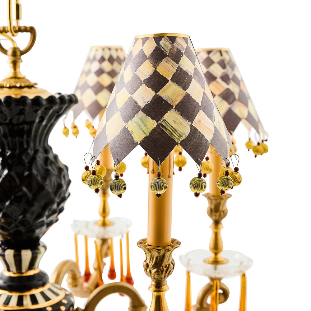 Decorative lamp with checkered shade and tassels on a white background