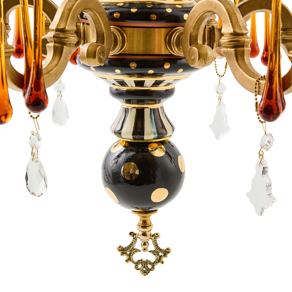 Decorative chandelier with black and gold design on a white background
