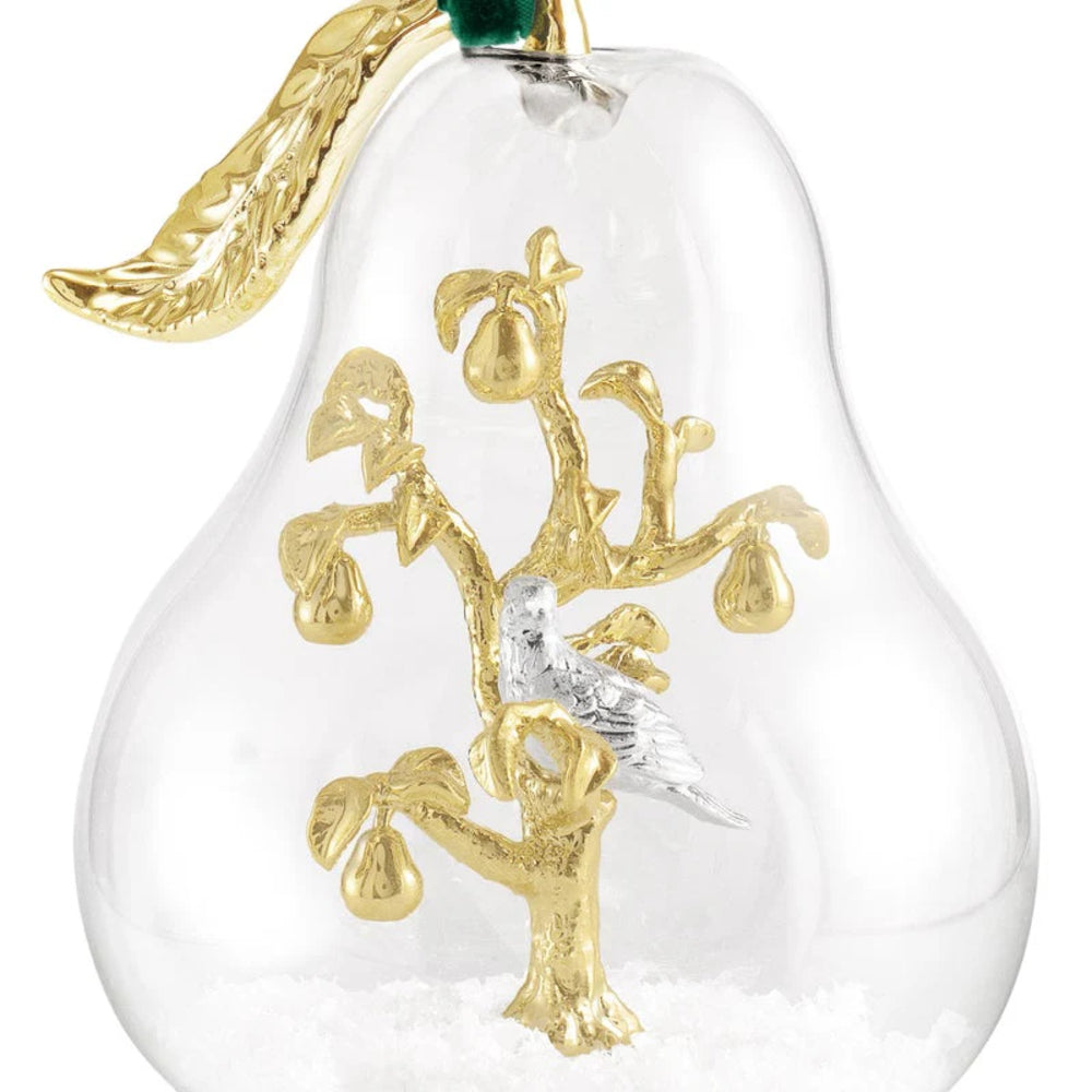 Decorative glass pear with gold branches and a bird on a white background.