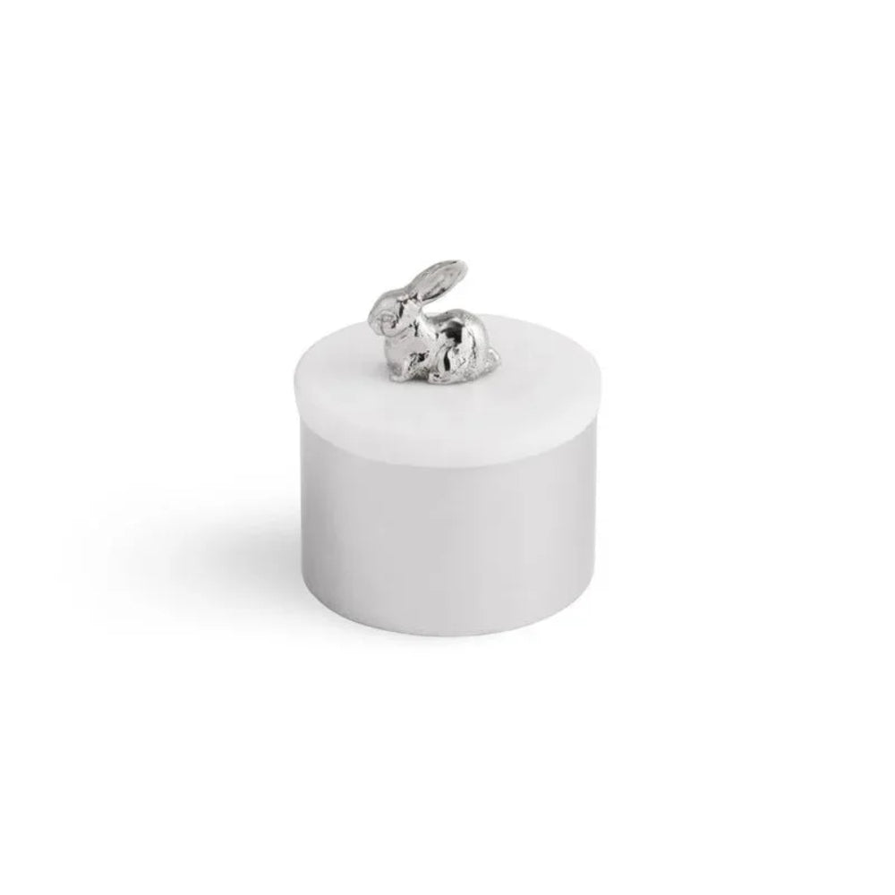 Small white ceramic jar with a silver rabbit figurine on a white background