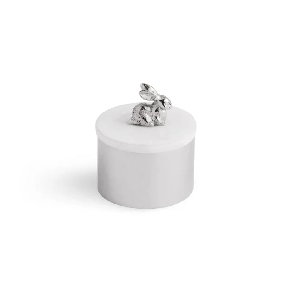 Small round white container with a silver rabbit on top against a white background