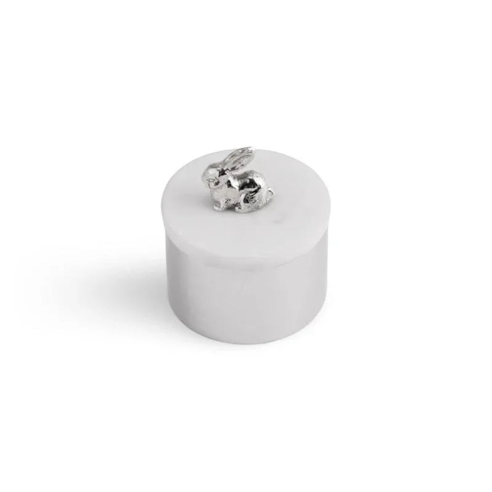 Small white ceramic container with a silver rabbit figurine on a white background