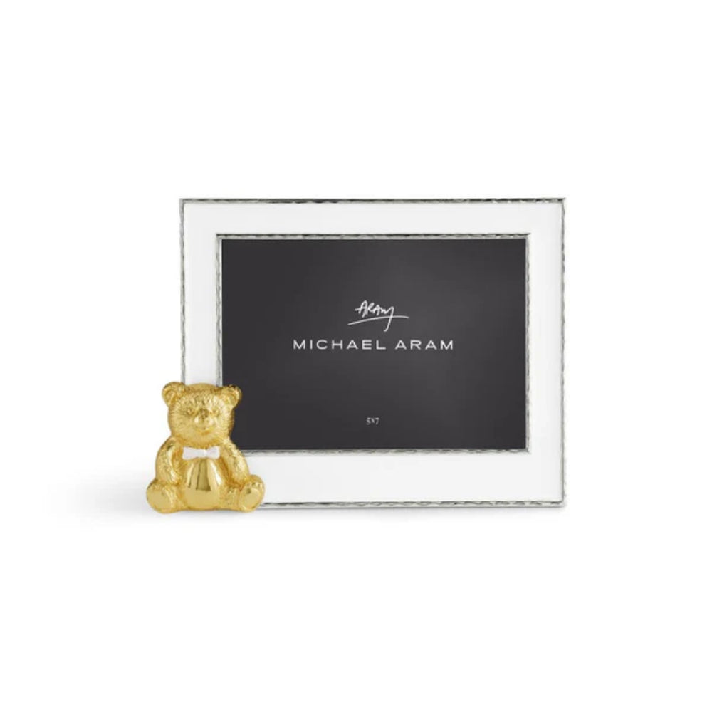 Silver picture frame with a gold teddy bear ornament on a white background