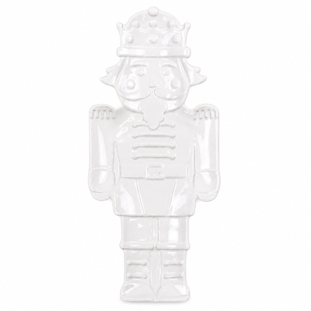 A glossy white ceramic nutcracker figurine on a solid white background.
