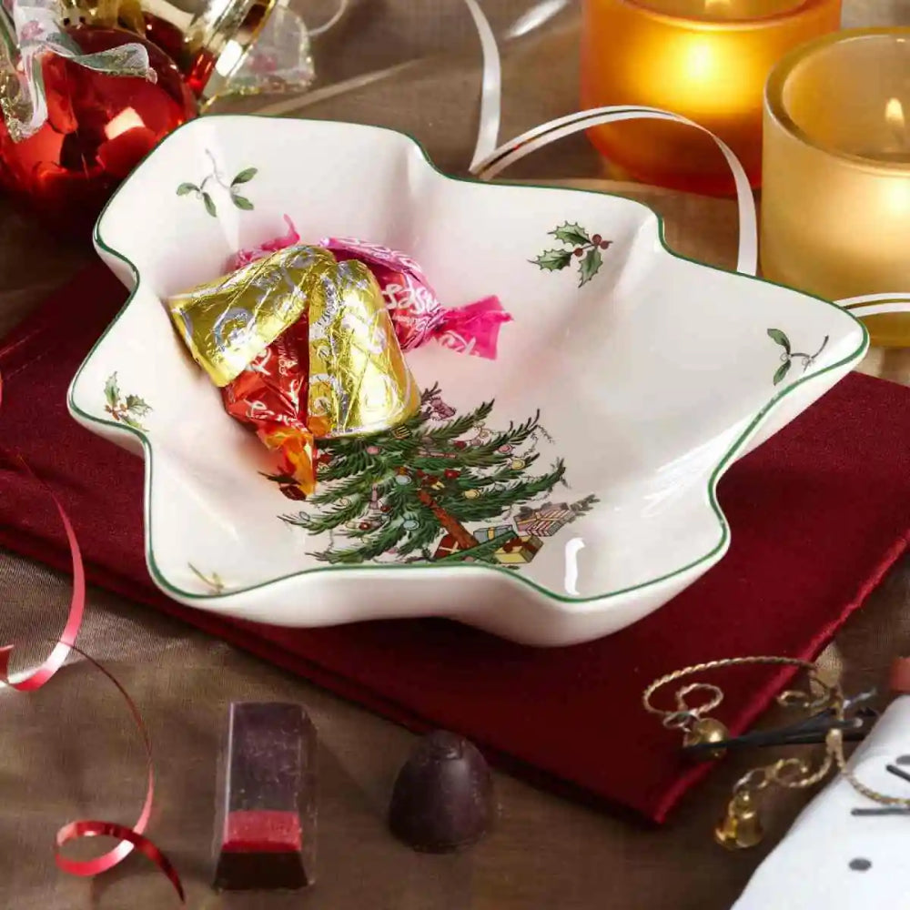Decorative Christmas-themed candy dish with wrapped candies on a festive table setting.