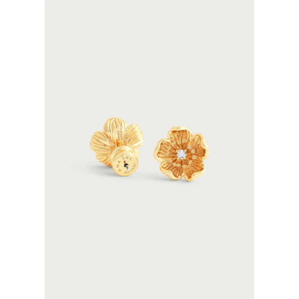 A pair of gold flower-shaped stud earrings, one shown from the front with a small clear center stone and the other from the side/back, set against a light gray background.
