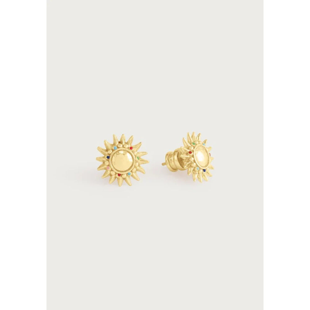 A pair of gold sunburst stud earrings with a central oval gold medallion and small blue and green stone accents, displayed on a light gray background.