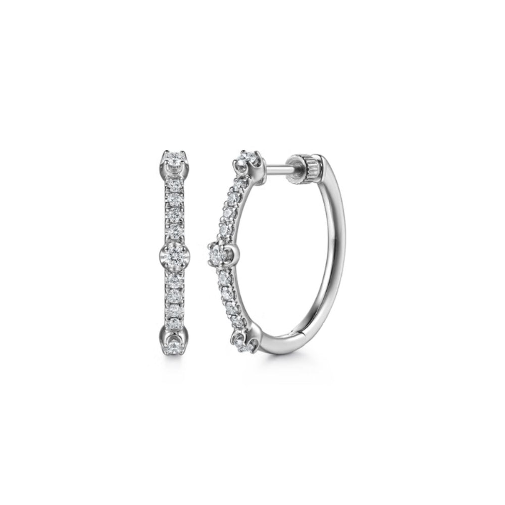 A pair of silver hoop earrings with a single vertical row of clear pavé-set round stones, shown on a plain white background.