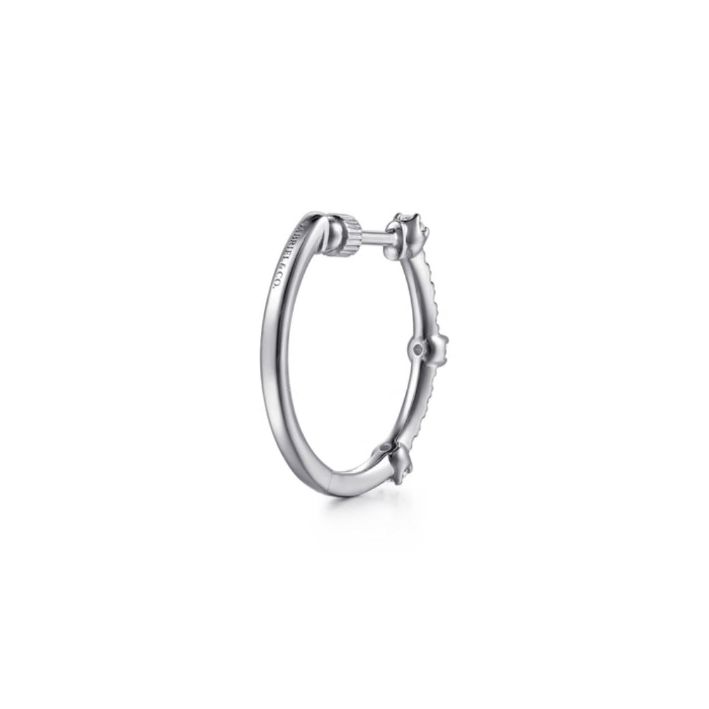 A silver hoop earring with a small central pavé stone and a textured side accent, shown on a clean white background.