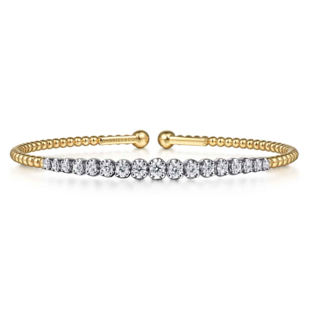 A yellow gold tennis bracelet featuring a row of round-cut clear gemstones across the front, displayed on a clean white background.