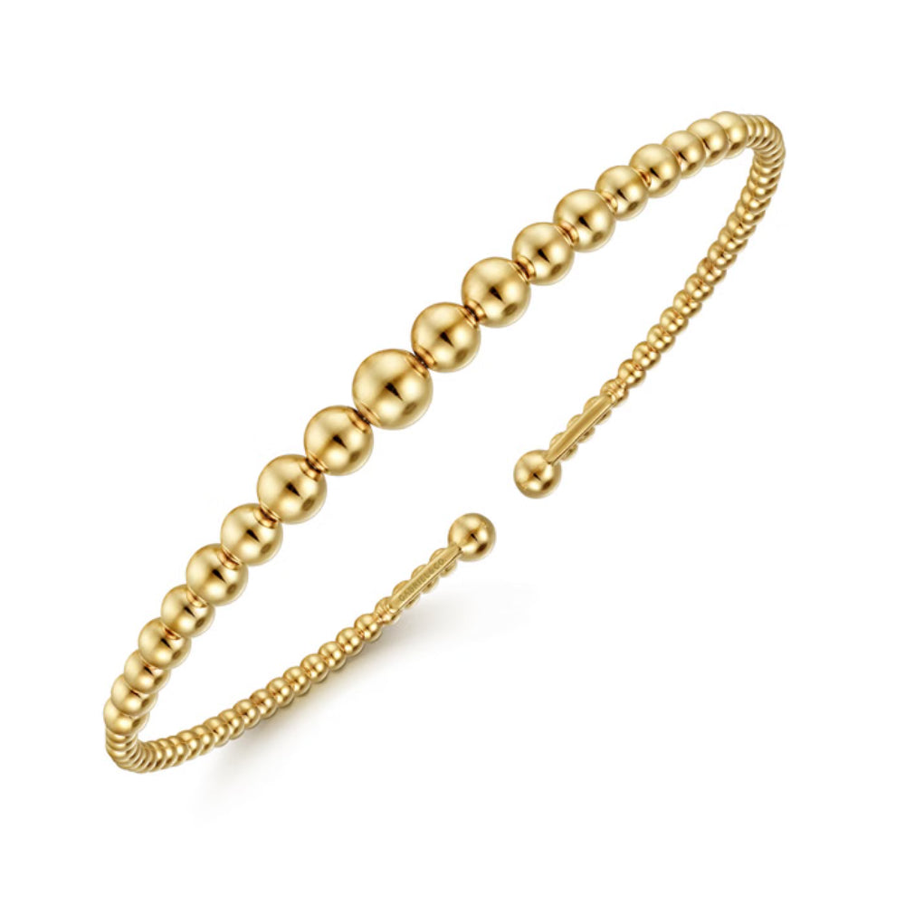 Gold beaded bracelet on a white background