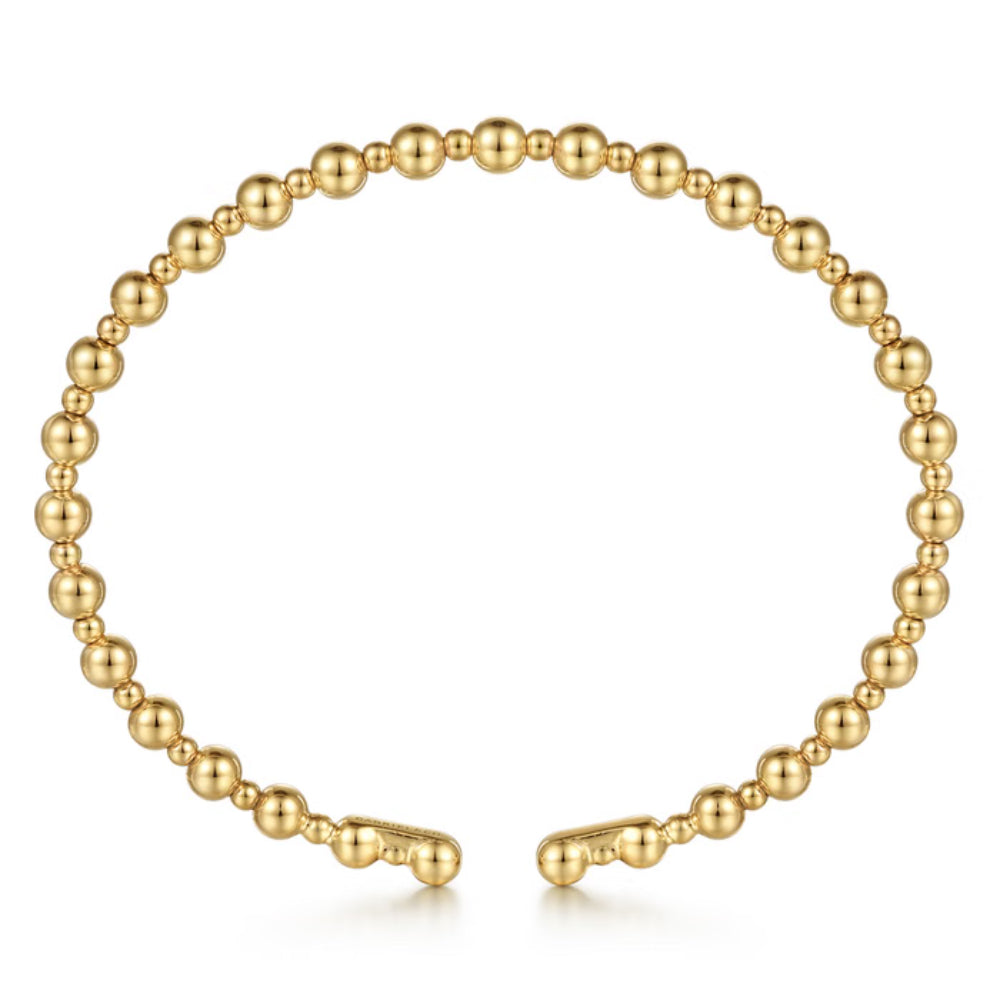 A gold beaded cuff bracelet with a polished finish, featuring small spherical beads connected along the outer curve and a matching clasp closure at the bottom, shown on a plain white background.