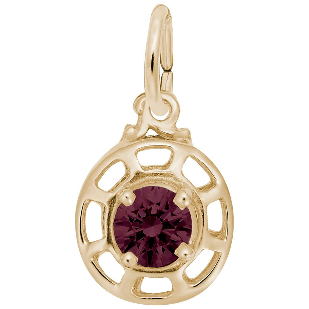 Gold charm with a dark red gemstone on a white background