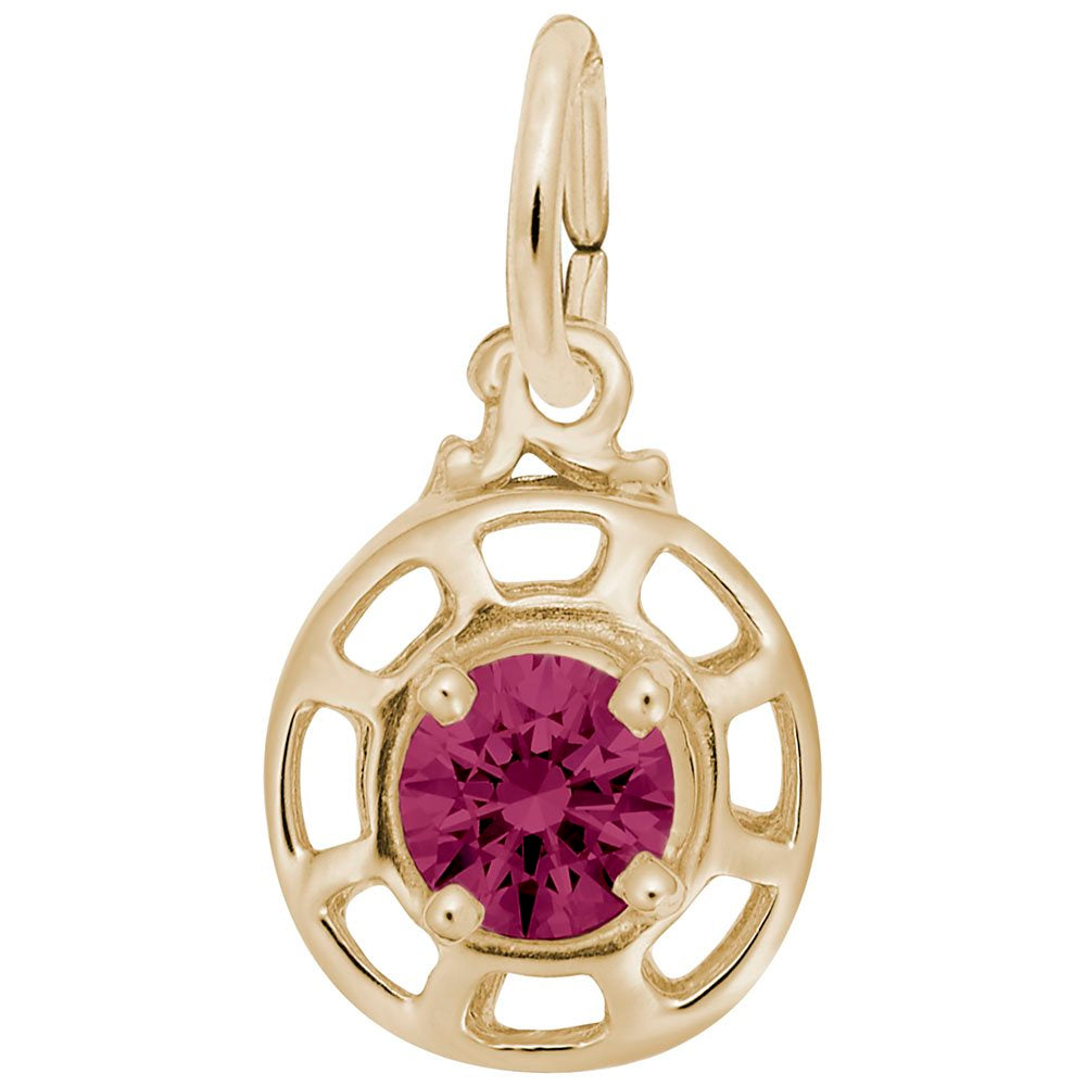 Gold charm with a red gemstone on a white background