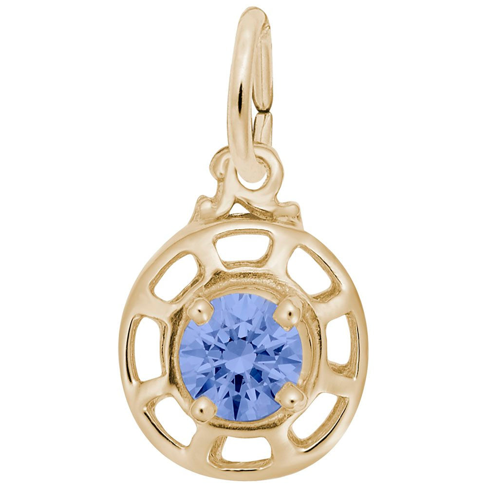 Gold charm with a blue gemstone on a white background