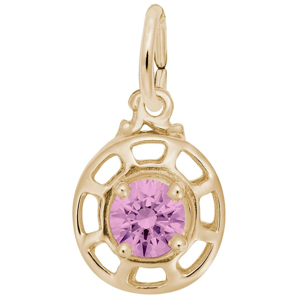 Gold charm with a pink gemstone on a white background