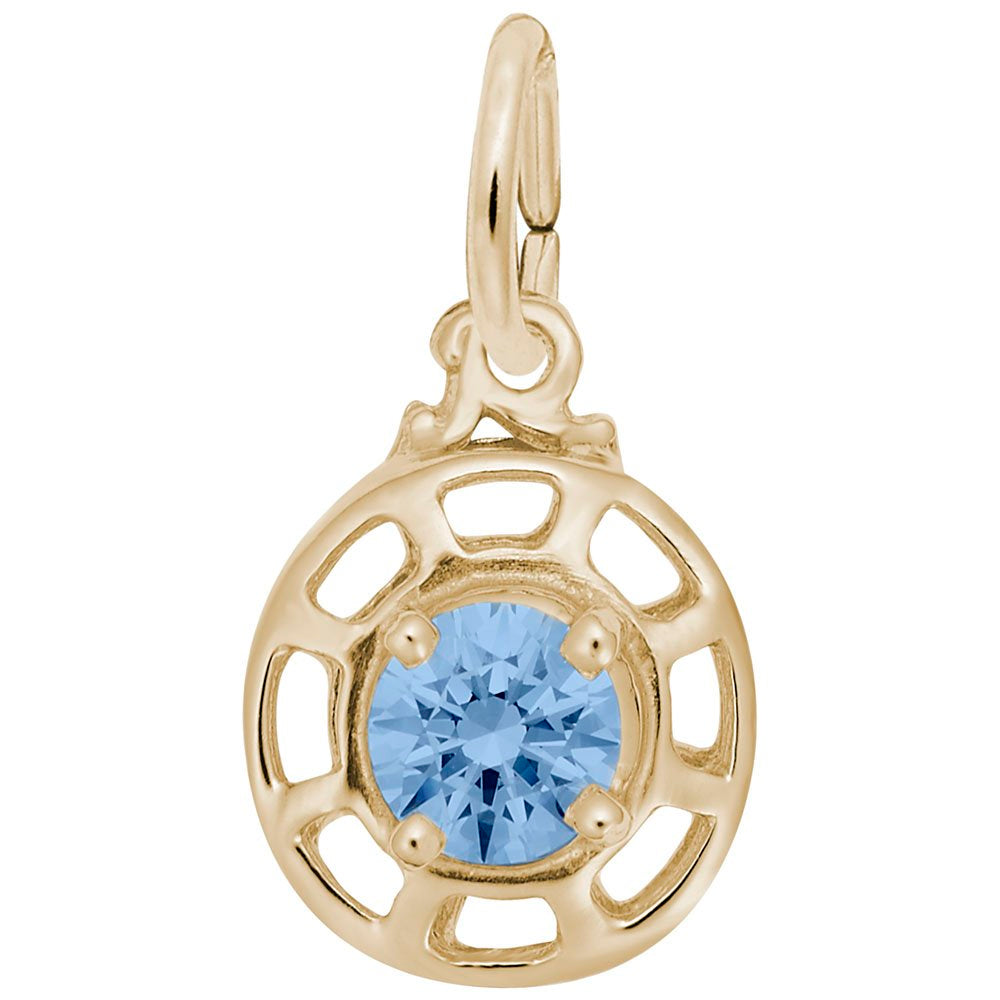 Gold charm with a blue gemstone on a white background