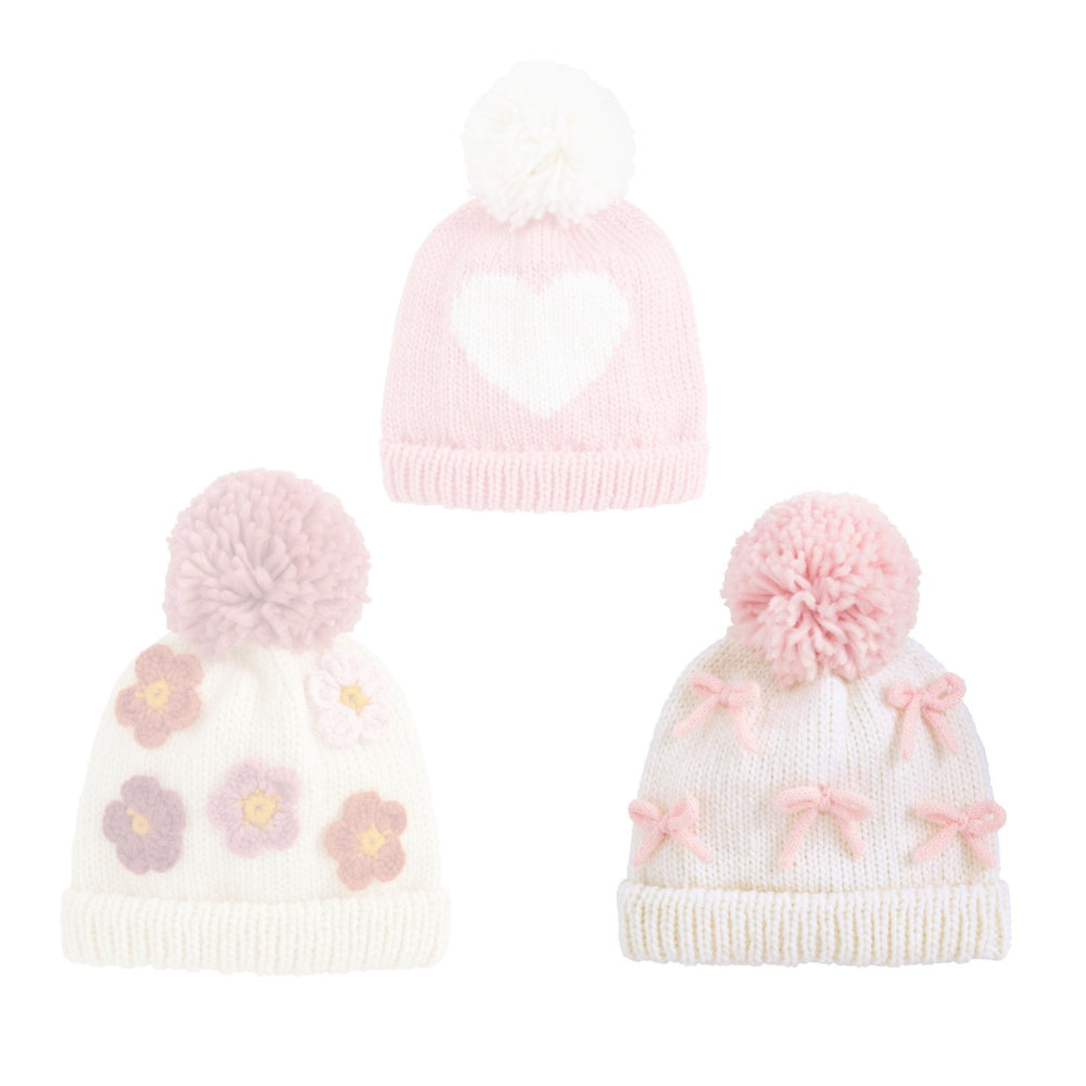 Bow knitted hat with pink bow  patterns and a pink pom-pom on a white background.