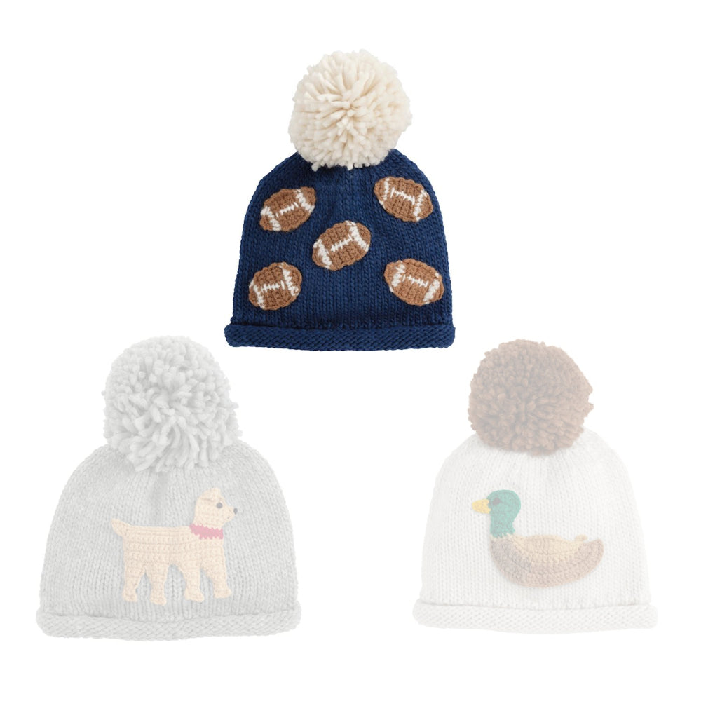 Navy blue football  knit hat with white pom-pom and brown football patches on a white background.