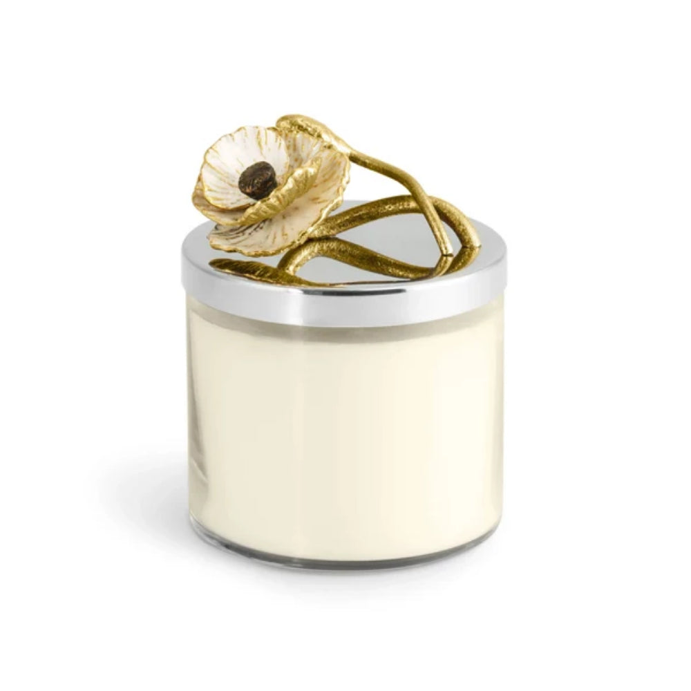 Decorative candle with gold flower on top against a white background