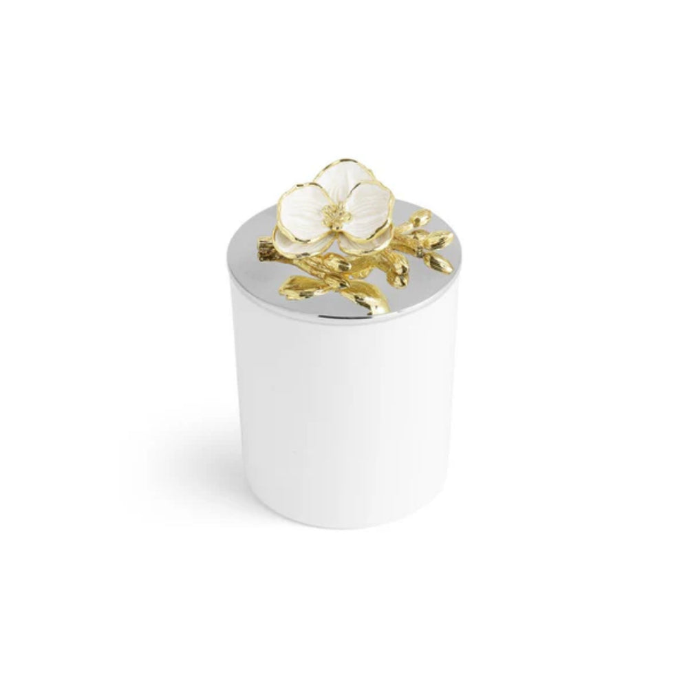 A side and top photo of a small white candle with a white and gold floral design on a silverplated lid on a white backround