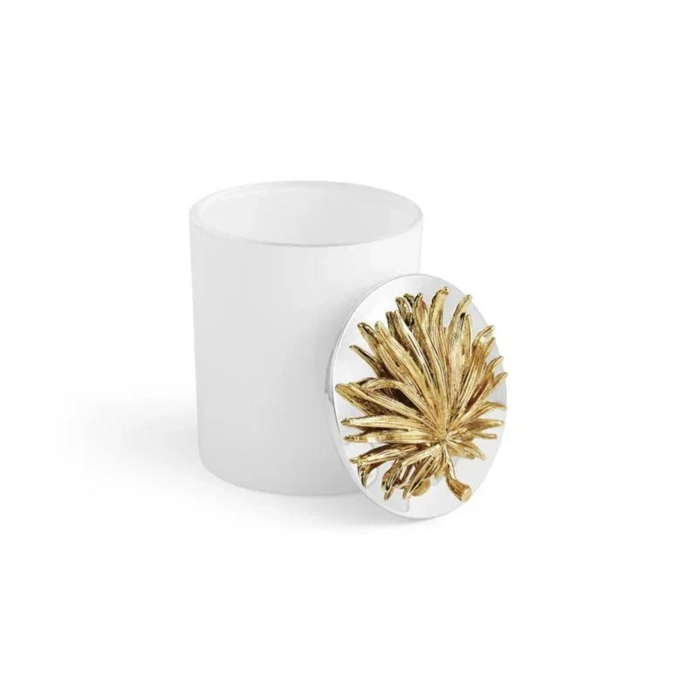White candle with a gold leaf design on a white background