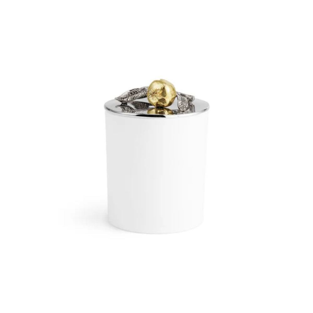 White candle with a gold and silver decorative pomegrante top a silverplated lid on a white background