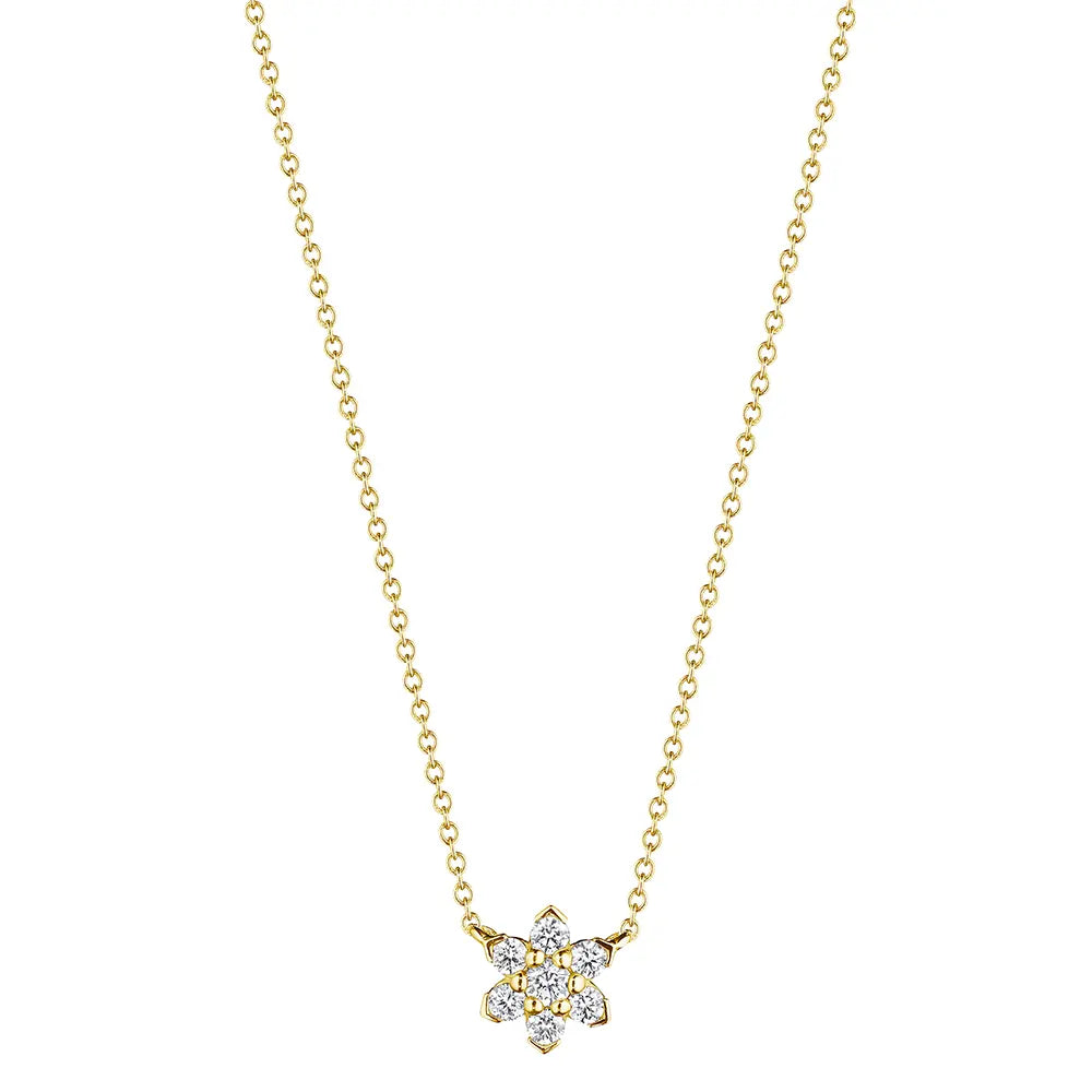 A delicate gold chain necklace featuring a small flower-shaped pendant paved with clear gemstones and accented with a central gold dot, shown against a plain white background.