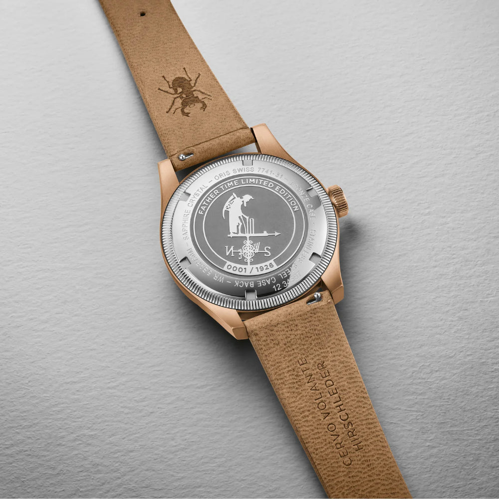Watch with brown leather strap and engraved silver dial on a gray background