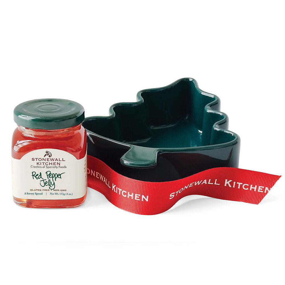 Jar of Stonewall Kitchen red pepper jelly with a Christmas tree-shaped dish and ribbon on a white background.