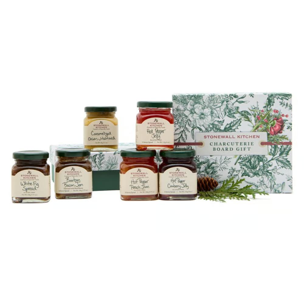 Stonewall Kitchen Charcuterie Board Gift set featuring six glass jars of assorted spreads arranged in front of a decorative gift box on a white background.