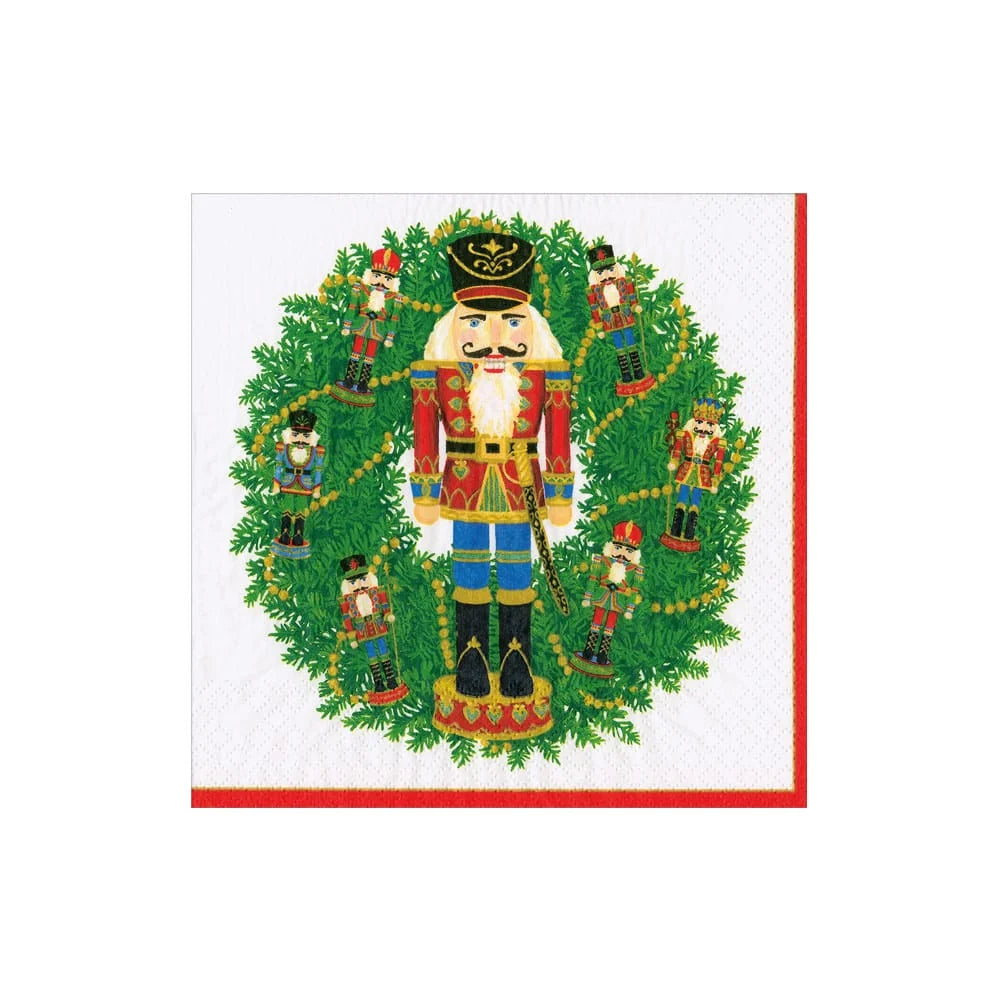 White napkin with a wreath with nutcrackers and one large one in the middle on a white backround. 