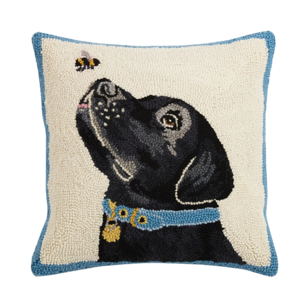 Decorative pillow with a black dog and bee design on a white background