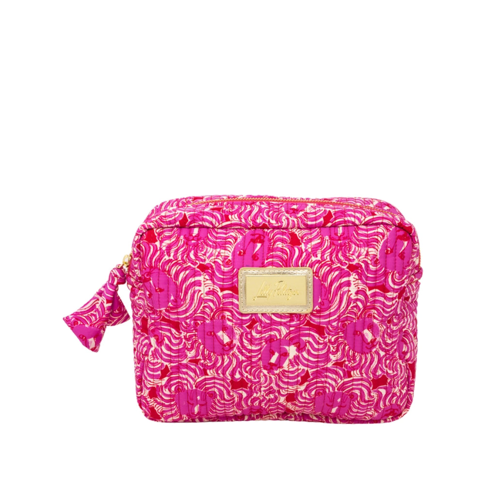 A bright pink cosmetic pouch with a gold and pink abstract wave pattern, featuring a gold-tone metal brand plaque on the front and a matching pink fabric tassel zipper pull, shown against a plain white background.