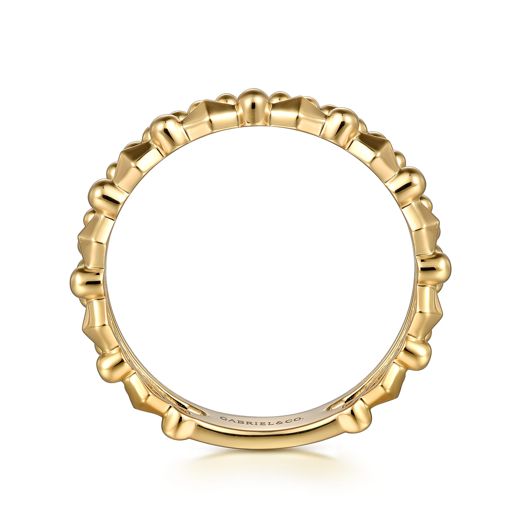 Gold ring with a textured design on a white background